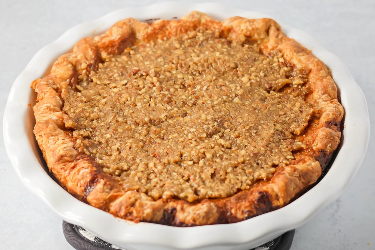Spreading the pecan topping on a sweet potato pecan pie.