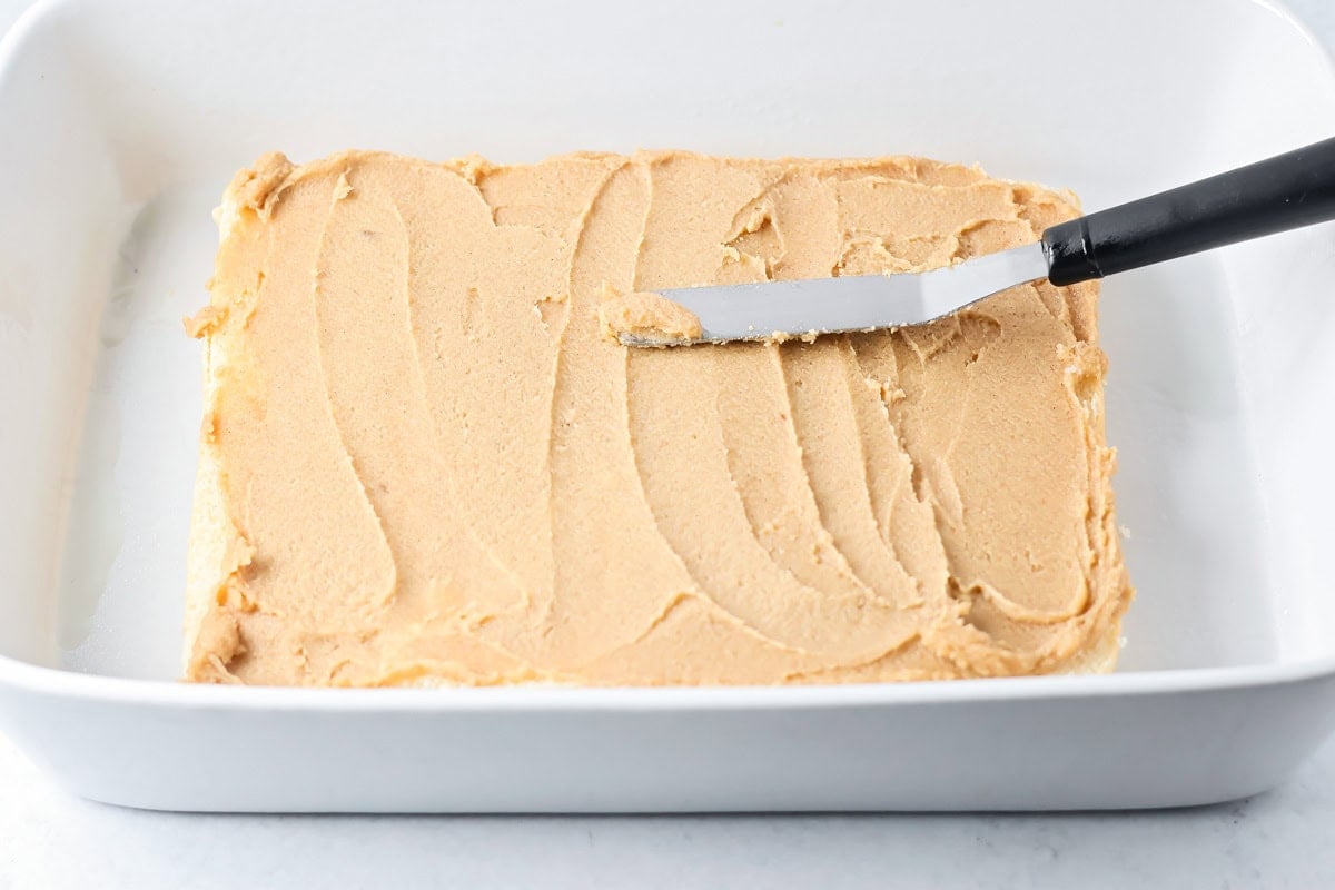 Spreading layers on Hawaiian King cinnamon rolls.