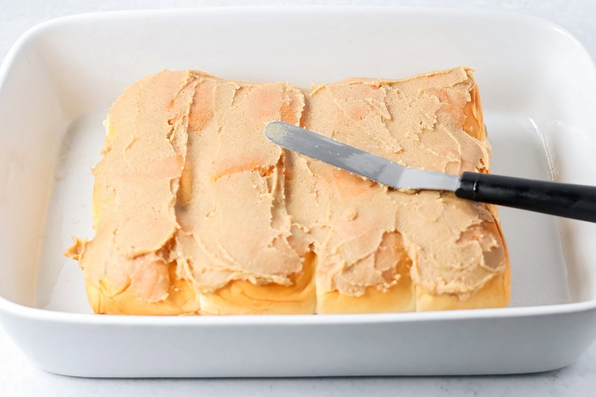 Spreading cinnamon mixture on Hawaiian king cinnamon rolls.