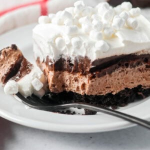 Hot chocolate lasagna on a white plate with a bite missing.