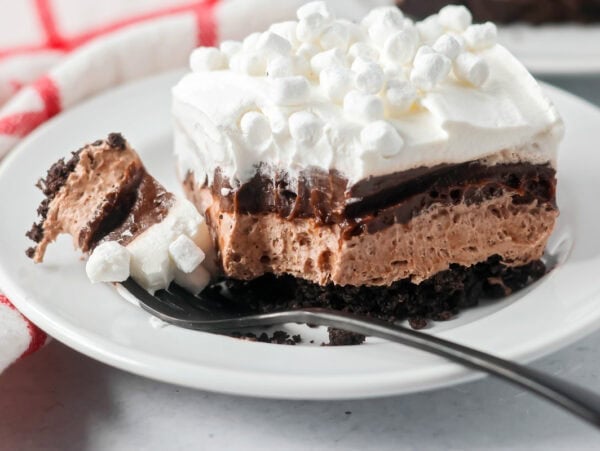Hot chocolate lasagna on a white plate with a bite missing.