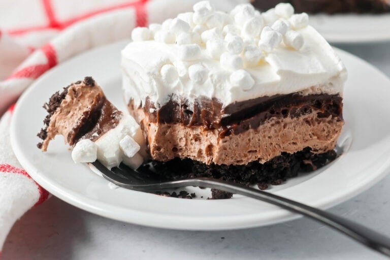 Hot chocolate lasagna on a white plate with a bite missing.