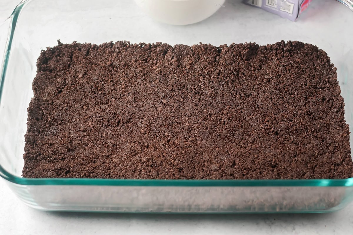 Spreading Oreo crust on the bottom of the hot chocolate lasagna.