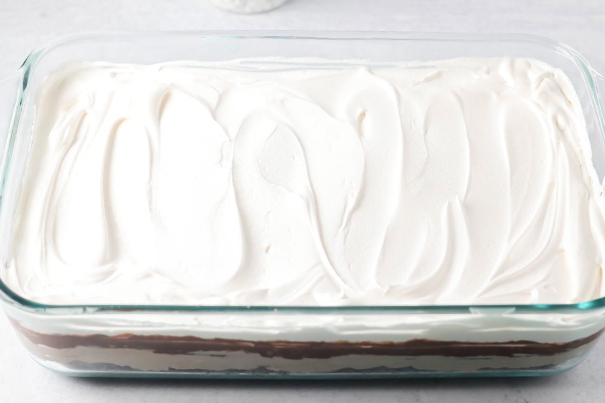 Whipped cream spread on the top of hot chocolate lasagna.