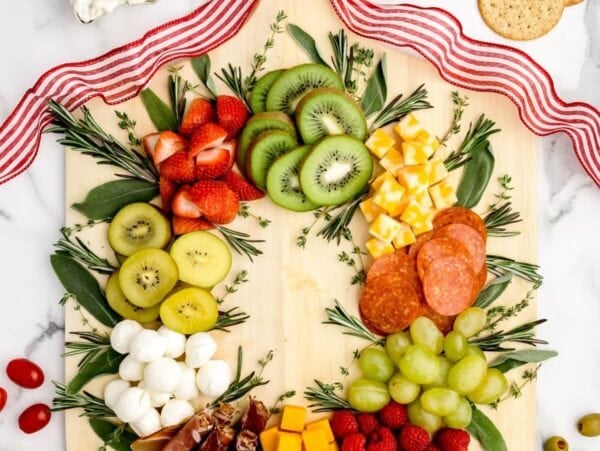 Christmas charcuterie board filled with fruits, veggies, cheese and meat.